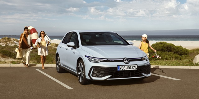 Der Volkswagen Golf GTE Vor Strandkulisse und einer Familie, die zum Auto läuft.
