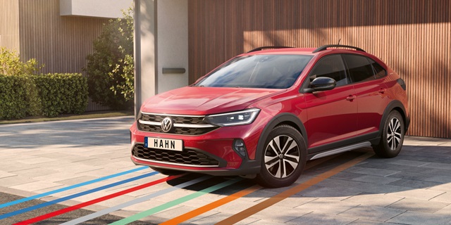 Roter VW Taigo parkt vor einer Garage