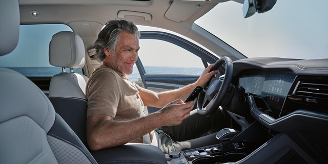Ein Mann bucht online mit dem Smartphone einen Mietwagen.