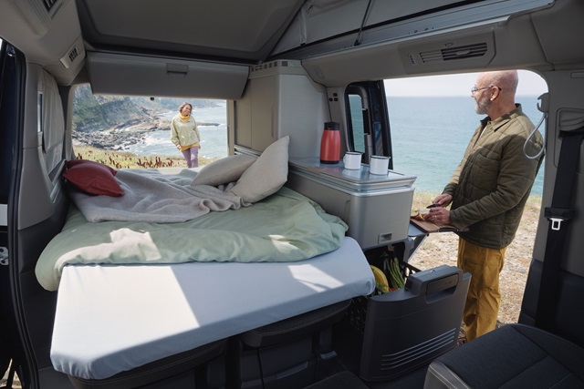 Der Innenraum des Volkswagen California mit Schlafbereich und Küche.