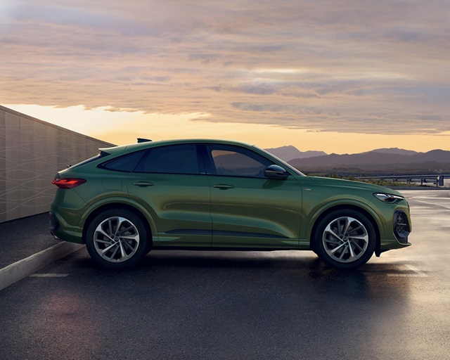 Ein grüner Audi Q5 Sportback in Seitenansicht parkend.