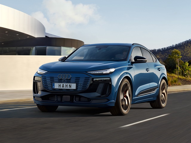Der Audi Q6 Sportback e-tron in Blau auf der Straße, markante Front mit LED-Leuchten und modernen Designelementen.