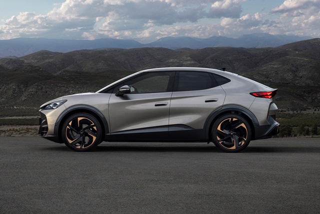Cupra Tavascan in Beige aus seitlicher Perspektive vor hügeliger Landschaft