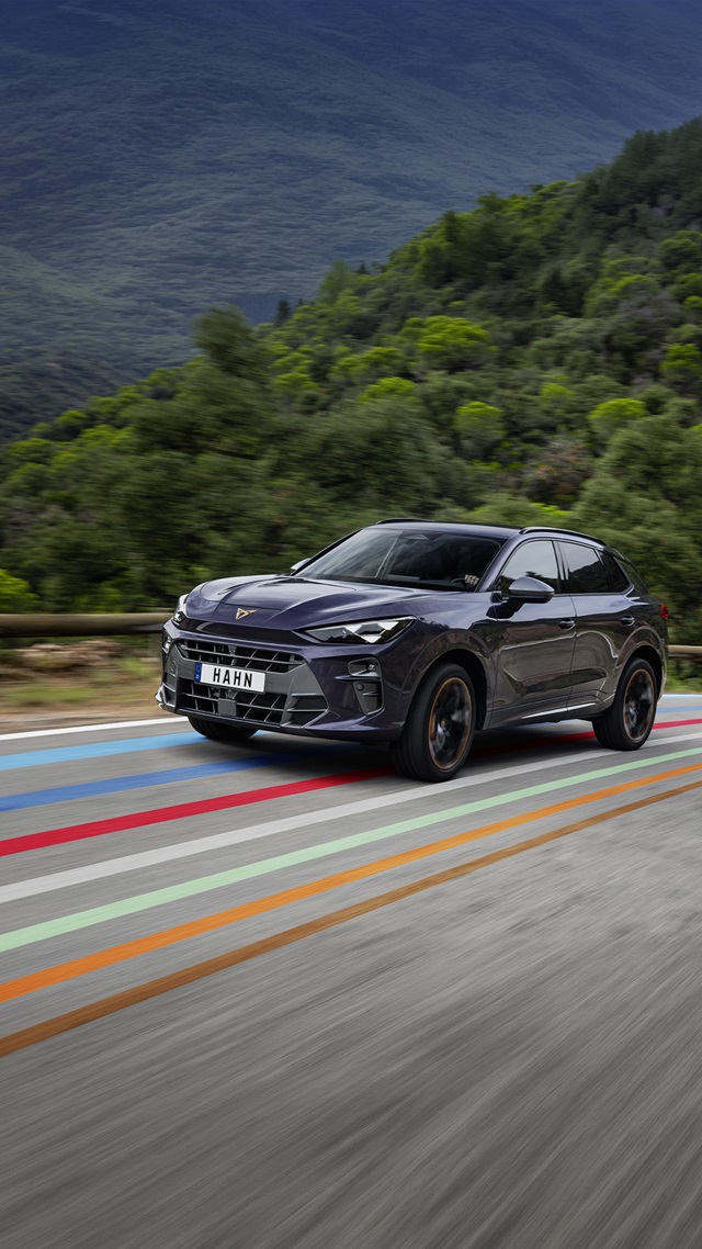 Cupra Terramar E-Hybrid SUV in lila Frontansicht auf einer Straße mit farbigen Linien und bewaldetem Hintergrund