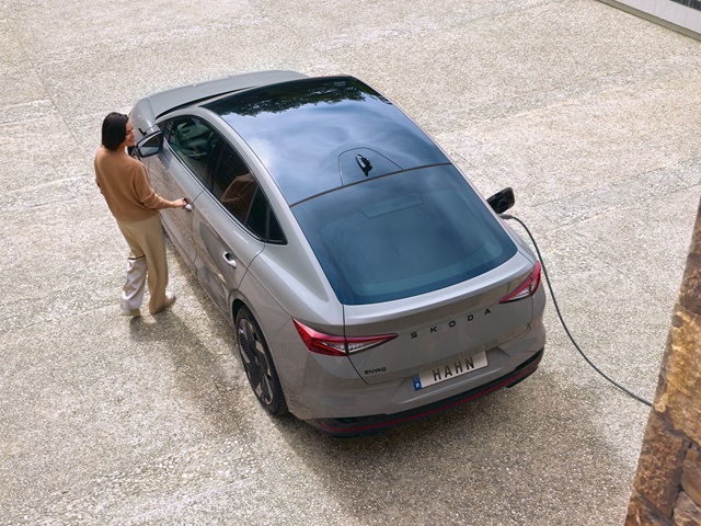 Škoda Enyaq Coupé in Grau von oben mit geöffneter Fahrertür und Ladekabel an der Rückseite