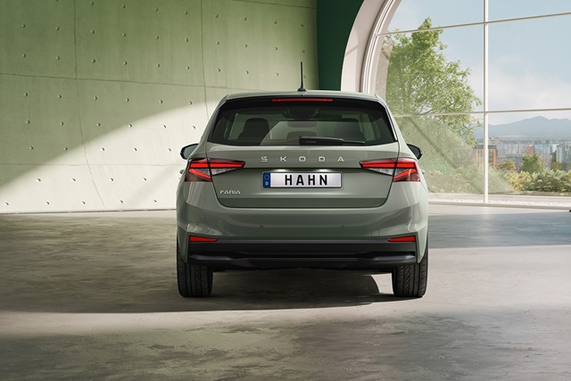 Hellgrüner Škoda Fabia von hinten mit sichtbarem Modellschriftzug und Kennzeichen 'HAHN' in einem modernen, hellen Raum mit großem Bogenfenster