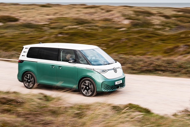 VW ID. Buzz in grün-weiß mit markantem Frontdesign und LED-Scheinwerfern auf einer Straße vor Dünenlandschaft