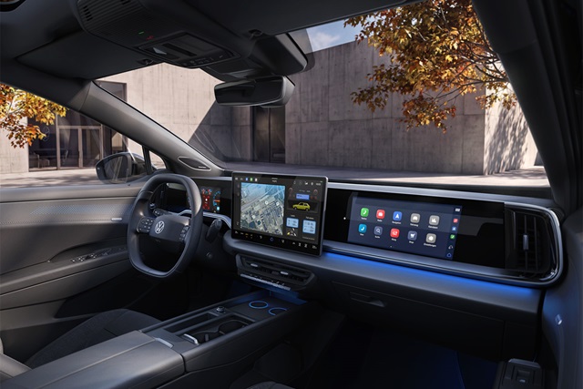 Innenraum des VW ID. Tiguan mit digitalem Cockpit, zwei großen Touchscreens und modernem Lenkrad vor urbaner Betonfassade