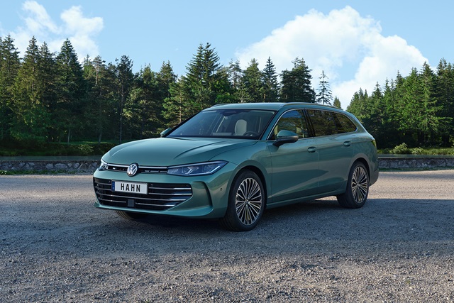 VW Passat Kombi in Grün auf einem Parkplatz vor Bäumen